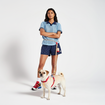 Woman in sports attire with a hands free dog leash on a white background