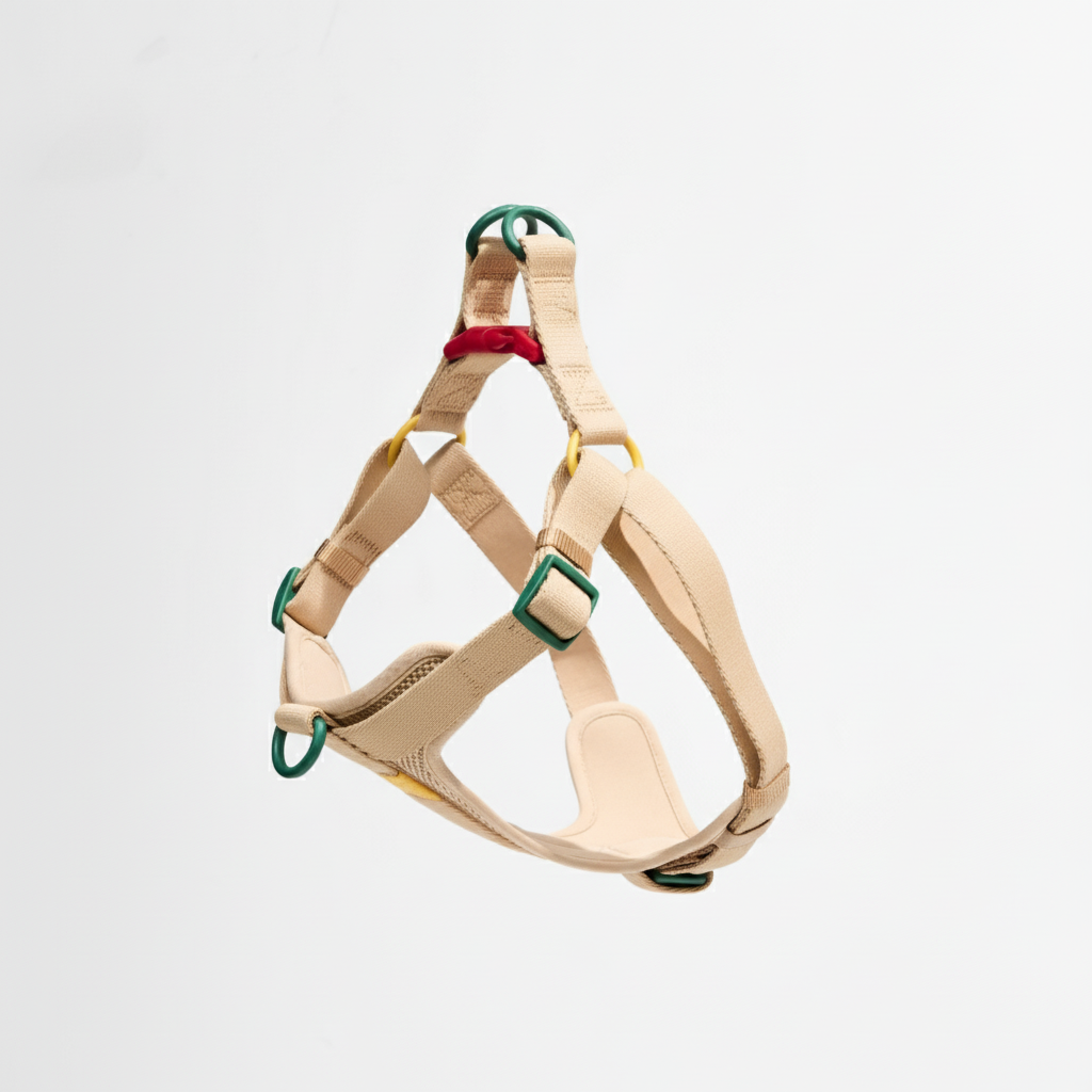 Beige dog harness with green buckles on a light gray background