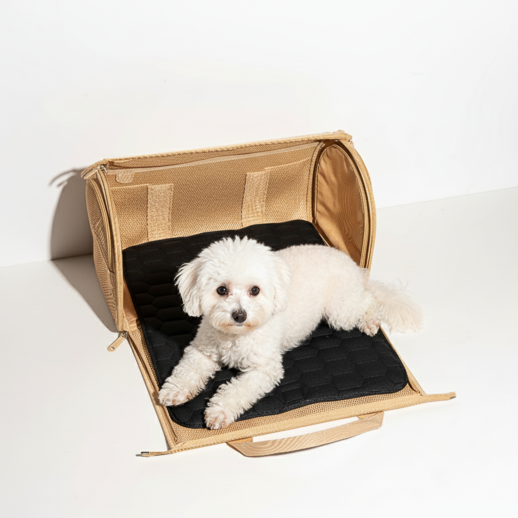 Small white dog lying on a black cushion inside a beige pet carrier.