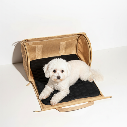 Small white dog lying on a black cushion inside a beige pet carrier.